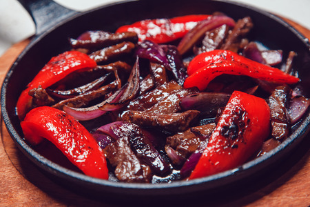 Mexican fajitos in a frying pan on a white table.の写真素材