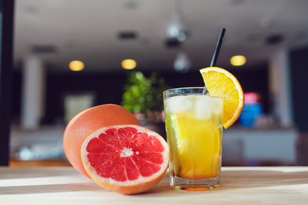 Glass of cold refreshing drink with fruits and cocktail straws on a table.の写真素材