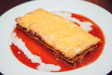 Tasty serving of traditional Italian lasagne with spicy tomato based ground beef.の写真素材