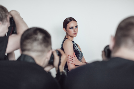 Photographers paparazzi take photos of woman in cocktail dresses.の写真素材