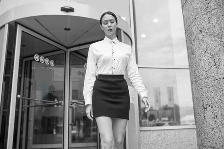 Beautiful business woman exits from business center.の写真素材