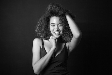 Portrait of a curly woman with freckles on dark background. Smiling girl.の写真素材