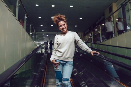 Curly haired girl with freckles in blank grey sweatshirt. Mock up.