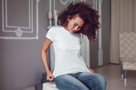 Curly haired girl with freckles in blank white t-shirt. Mock up.の写真素材