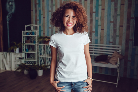 Curly haired girl with freckles in blank white t-shirt. Mock up.の写真素材
