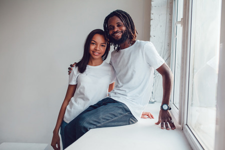 Beautiful African American couple in white t-shirts. Mock-up.の写真素材