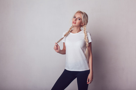 Beautiful girl with two braids in a white T-shirt. Mock-up.