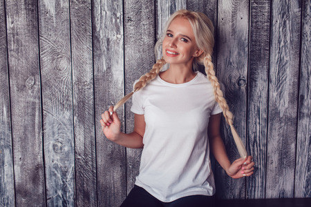 Beautiful girl with two braids in a white T-shirt. Mock-up.の写真素材