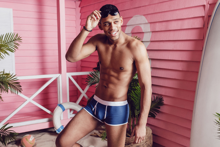 Sexy african american man in shorts standing on the sand.の写真素材