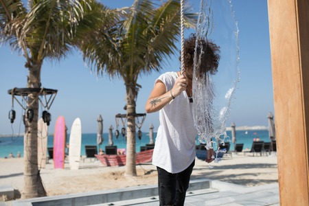 Young man poured water on the beach.の写真素材