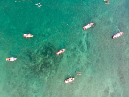 A lot of bright and colorful fishing boats in the ocean.