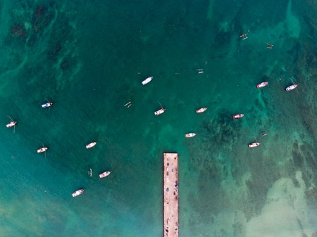 A lot of bright and colorful fishing boats in the ocean.の写真素材