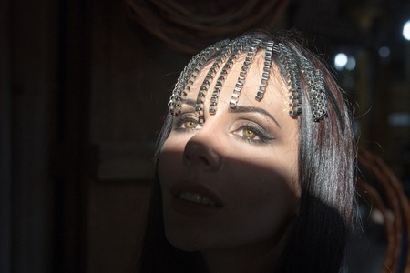 Portrait of a young beautiful woman in Arabic style with a decoration on her head.