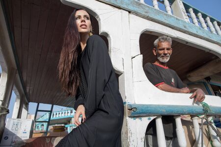 Dubai/UAE - March 13, 2018: A woman in abay on an old wooden boat.
