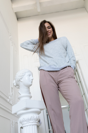 Smiling young woman in a gray sweatshirt. Mock-up.の写真素材