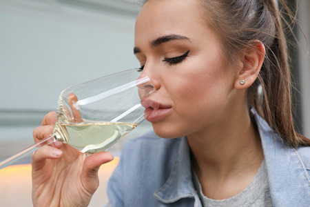 Portrait of a beautiful girl with a glass of white wine.の写真素材