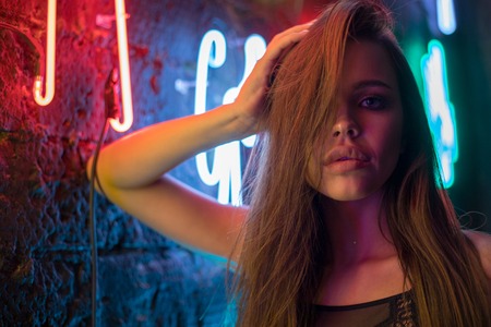 Sexy young woman in beautiful lace lingerie on the background of neon lamps.の写真素材