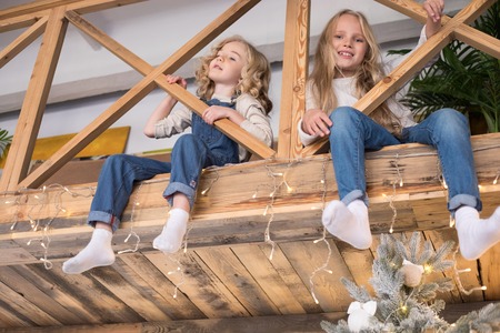 Two beautiful little girls are sitting on the landing.