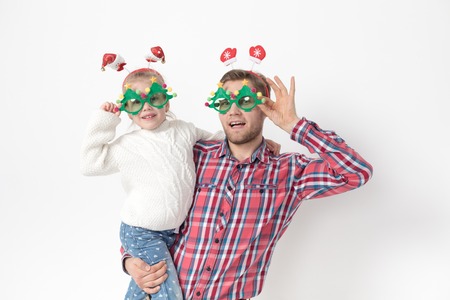 Father and daughter in funny Christmas accessories on a white background.の写真素材