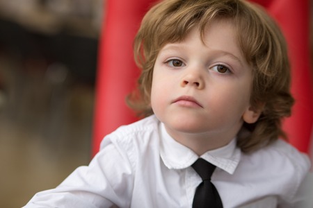 Little businessman is sitting at the office table.の写真素材