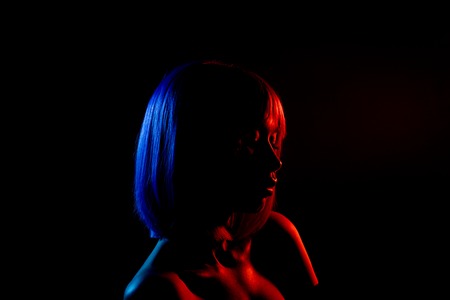Woman in colorful bright lights posing in studio, portrait of beautiful sexy girl.の写真素材