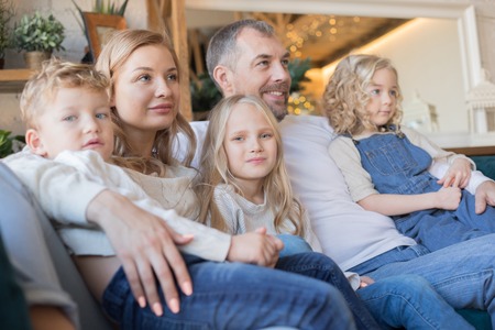 Happy and friendly family hugging on the couch.