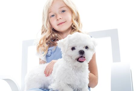 Cute little girl with funny puppy on white background.の写真素材