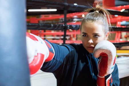 CHELYABINSK, RUSSIA â June 8, 2019: A young woman is practicing punches on a punching bag. Girl boxing.のeditorial素材