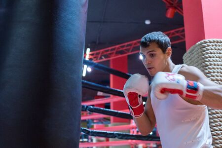 CHELYABINSK, RUSSIA â June 8, 2019: A man is practicing punches on a punching bag. Girl boxingのeditorial素材