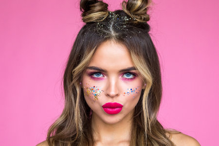 Girl with bright makeup on a pink background. Glitter Makeup.の写真素材