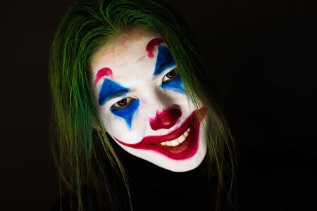 KAZAKHSTAN, KOSTANAY - OCTOBER 21, 2019: Make-up Joker with green hair for Halloween. Close-up face on black background.のeditorial素材