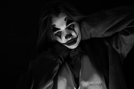 KAZAKHSTAN, KOSTANAY - OCTOBER 21, 2019: Make-up Joker with green hair for Halloween. Close-up face on black background.のeditorial素材