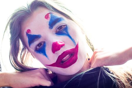 Portrait of a girl with clown makeup isolated on white background.