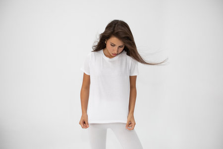 Beautiful brunette girl in a white T-shirt posing on white backgroundの写真素材