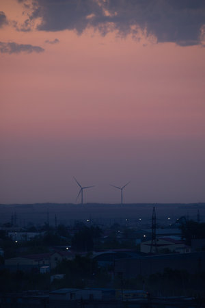 The Beautiful Wind Turbines Gracefully Silhouetted Against a Serene and Misty Sunset Sky