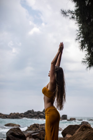 An Elegant Model Gracefully Posing Amid Nature by the Beautiful and Peaceful Shorelineの写真素材