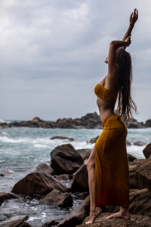 An Elegant Model Gracefully Posing Amid Nature by the Beautiful and Peaceful Shorelineの写真素材