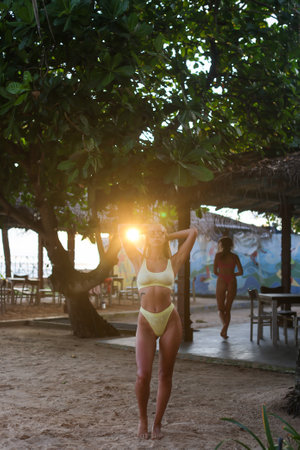 Sunset Beach Vibes Women Enjoying Their Time in a Beautiful Tropical Paradise Settingの写真素材