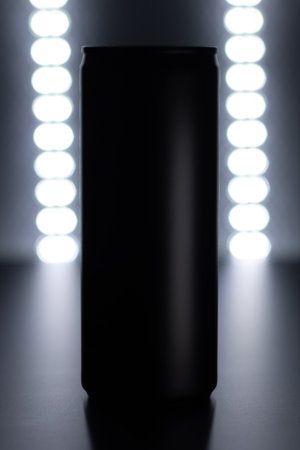 Black Aluminum Can with Futuristic Lighting on Metallic Surfaceの写真素材