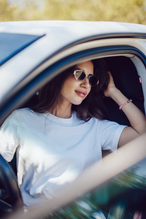Stylish Woman Sitting in Car Wearing Sunglassesの写真素材