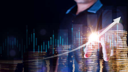 Double exposure of  Businessman touches stack of money coin with a trading graph for finance...