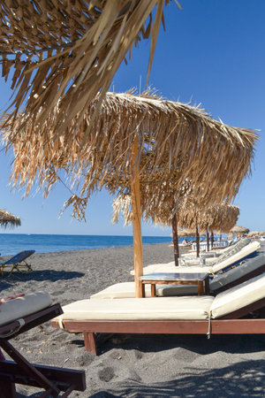 Beach chairs and umbrellas on the beach in santorini, Greeceの写真素材