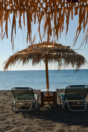 Umbrella and Chairs on the Beach in the Santorini islandの写真素材