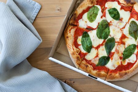 Top view VERY HOT Italian Pizza on white wooden table with mushrooms, basil, tomato, olives and...