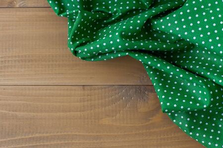 Checkered napkin on wooden background. Home comfort.