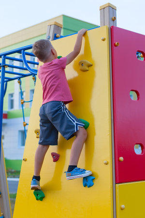 a little boy in a red t-shirt on the Playground. outdoor games. mobile games.の写真素材