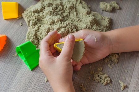 hands little girl playing with kinetic sand. the development of fine motor skills. educational gamesの写真素材