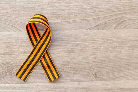 St. George ribbon. George ribbon. Georgievsky ribbon. St. George ribbon on a dusty wooden board.の写真素材