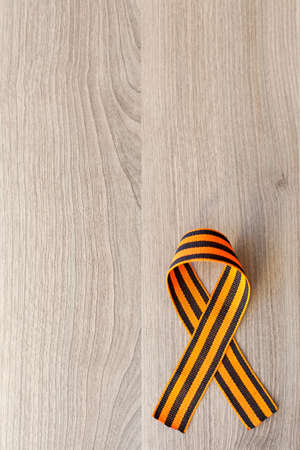 St. George ribbon. George ribbon. Georgievsky ribbon. St. George ribbon on a dusty wooden board.の写真素材