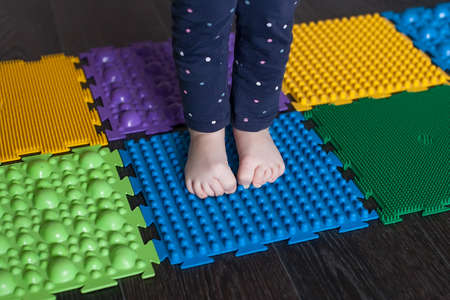 Foot massage mat for babies. Prevention of flat feet and hallux valgus. Orthopedic massage puzzle mats for the development of children.の写真素材